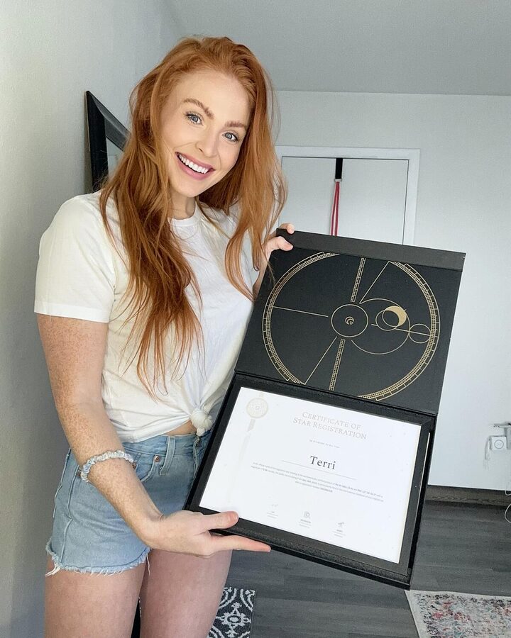 Un cliente sonríe con su certificado de estrella enmarcado dentro de la caja de regalo